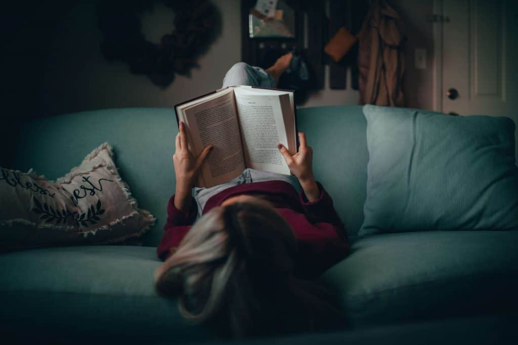 Dziewczyna czytająca książkę na kanapie 